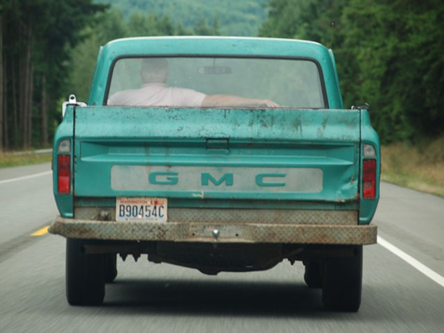man driving green truck